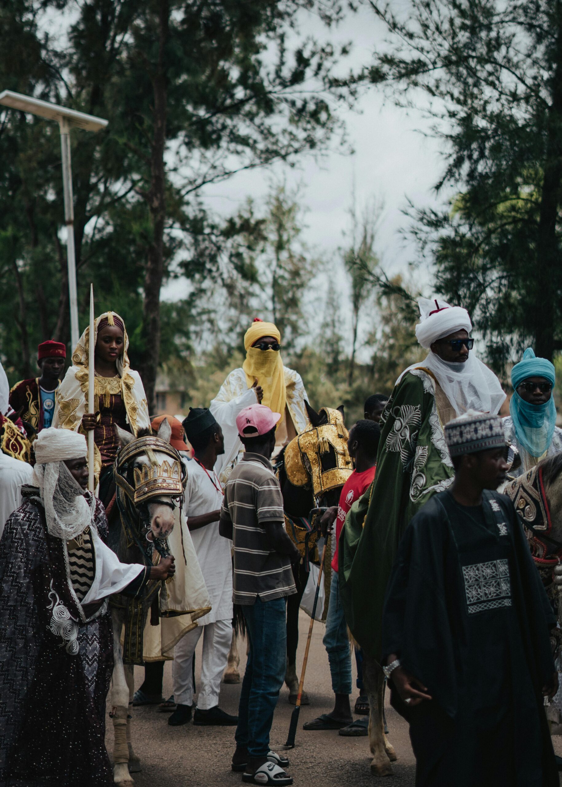 People in traditional attire gathered outdoors at a cultural event.